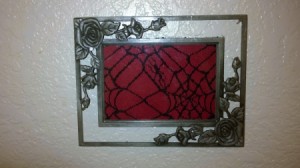 Spiderweb lace inside a silver filigree frame.