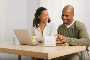 Couple looking at recipes both online and using recipe box