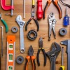 Variety of tools displayed on wooden background