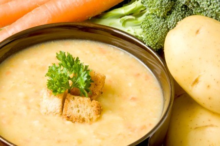 A bowl of a hearty potato soup made with many vegetables.