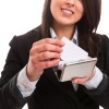 A woman placing a business card in a holder.