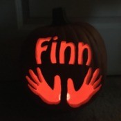 foam pumpkin with child's name and handprints lit with tea light