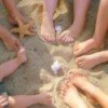 Christmas card photo of family members feet in the sand.