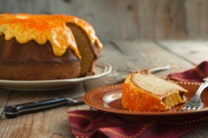 A pumpkin spice cake with orange cream cheese frosting.