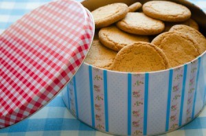 A cookie tin filled with cookies.