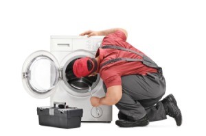 A repairman looking at a washing machine.