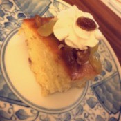 A slice of autumn grape cake with whipped cream.