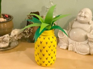 glass jar painted like a pineapple with paper leaves