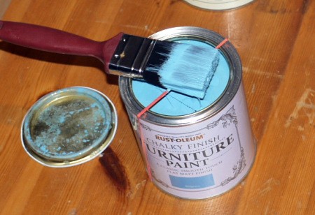 An elastic band stretched across the paint can opening.