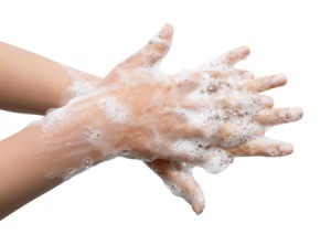 Hands being washed, trying to remove sunless tanning lotion.