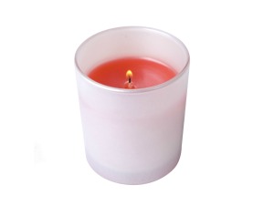 A votive candle holder with a red lit candle it in.