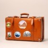 A leather suitcase with travel stickers.