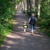 A mom and child walking in the woods.