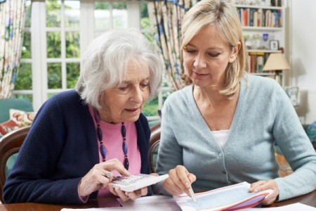 A senior woman discussing her finances with her daughter.