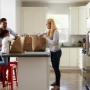 A family unpacking groceries in the kitchen.
