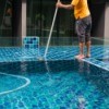 A man cleaning a swimming pool.