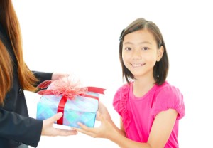 A girl giving her teacher a gift.