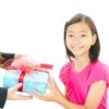 A girl giving her teacher a gift.