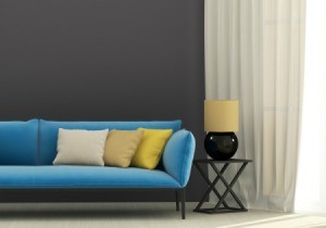 A blue couch on a dark gray wall.