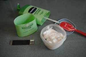 lotion bottle with bottom cut off and remaining product being put in a small container
