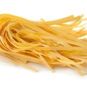 A serving of dried egg noodles, ready to be cooked.