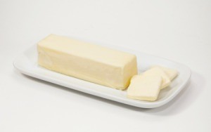 A stick of margarine on a white dish.
