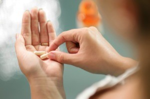 A woman taking a supplement pill.