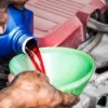 A mechanic pouring transmission fluid into a funnel.