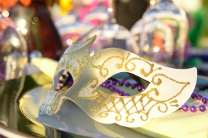 A mask sitting on a decorated table at a masquerade.