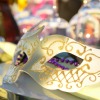 A mask sitting on a decorated table at a masquerade.