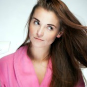 A woman blowdrying her thin and fine brown hair.