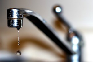 A kitchen faucet with a drip of water.