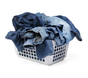 A laundry hamper of filled with jeans.