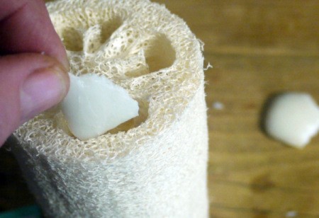 putting bar soap pieces inside a loofah