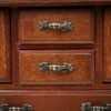 An antique dresser with many drawers.