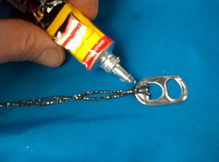 adding glue to back side of pull tab