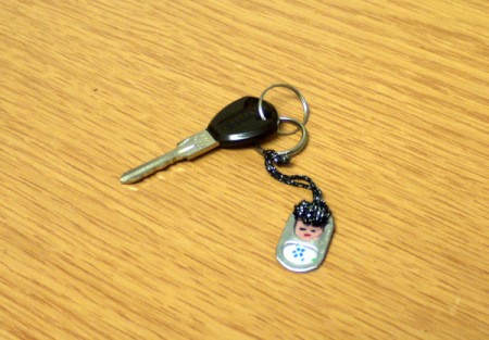 key attached to fob lying on wood grain surface
