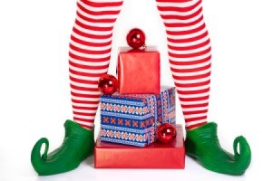Striped elf legs over a pile of presents.
