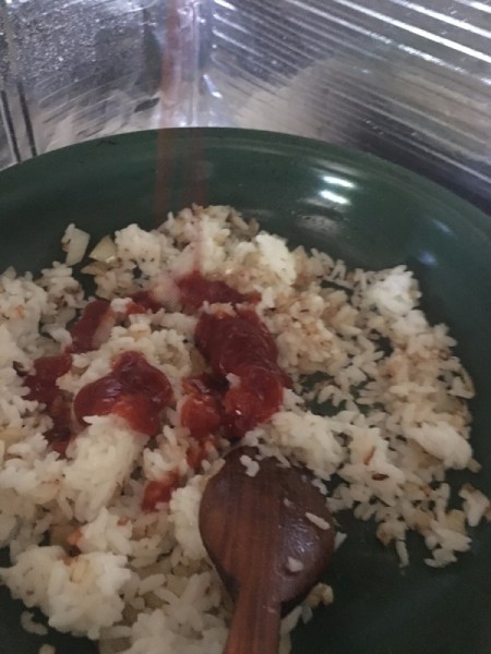 rice, onion and catsup in pan