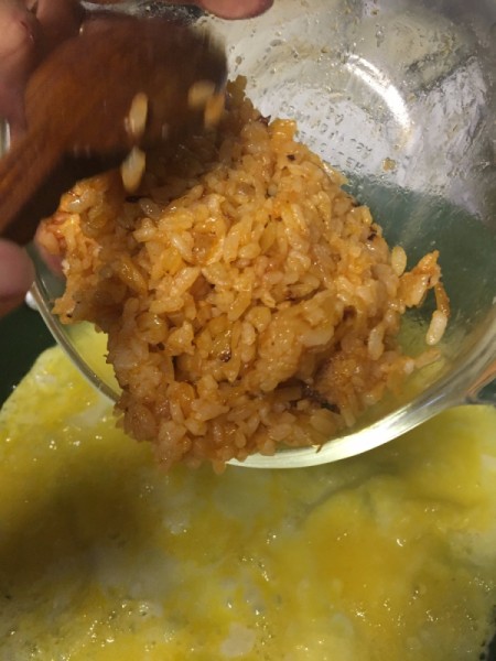 cooked mixed rice, onion and catsup in pan