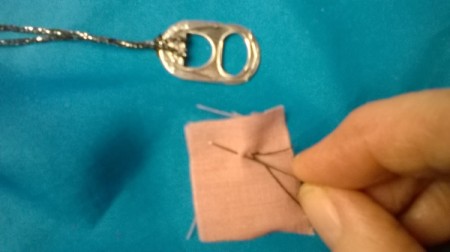 using black thread to make eyes on fabric scrap