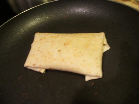 folded filled tortilla in pan