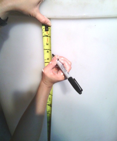 using a measuring tape and Sharpie to mark divisions on cylinder