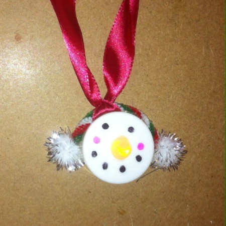 snowman with white muffs and red ribbon