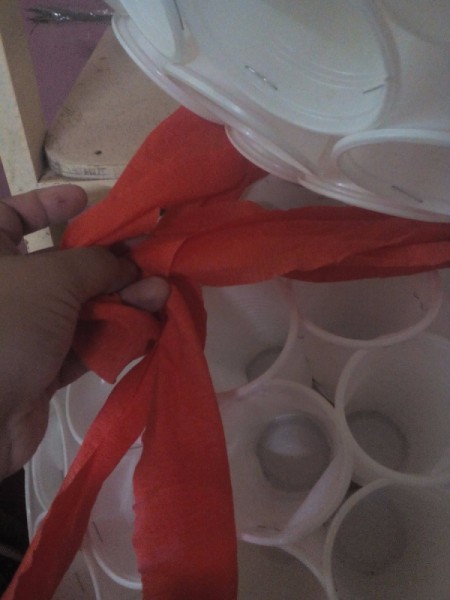 tying scarf at the juncture of the small and large half spheres