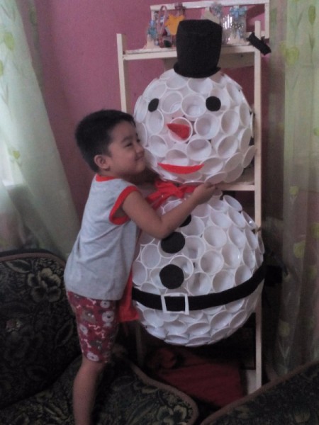 little boy hugging the snowman