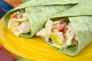Two sandwich wraps using spinach tortillas.