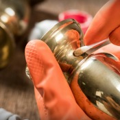 A brass candlestick being polished.