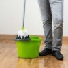 A mop and bucket on a hardwood floor.