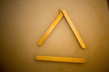 Removing the unglued side of the triangle.